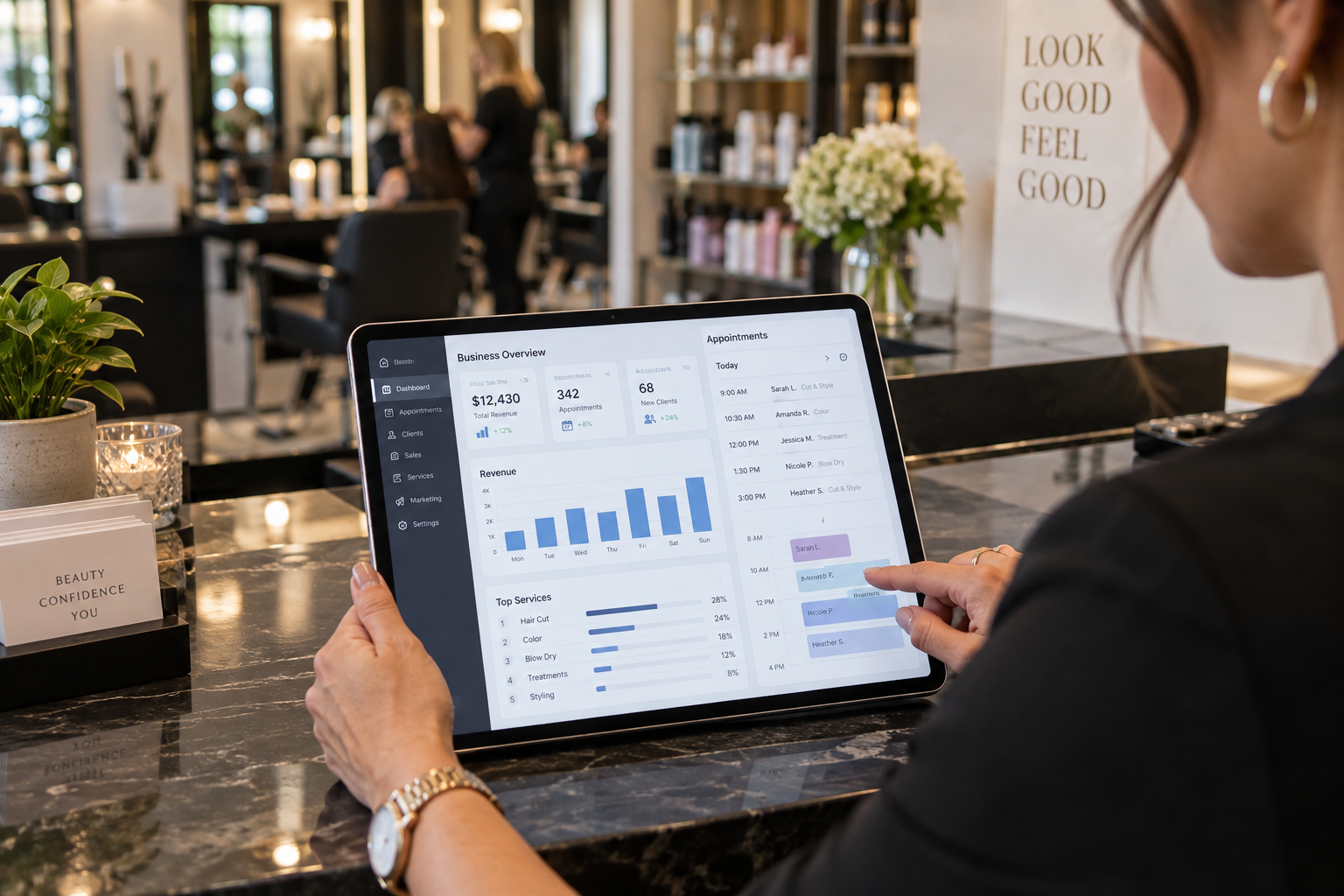 A salon owner reviewing point of sale financial reporting and appointment schedules on a tablet at a modern reception desk